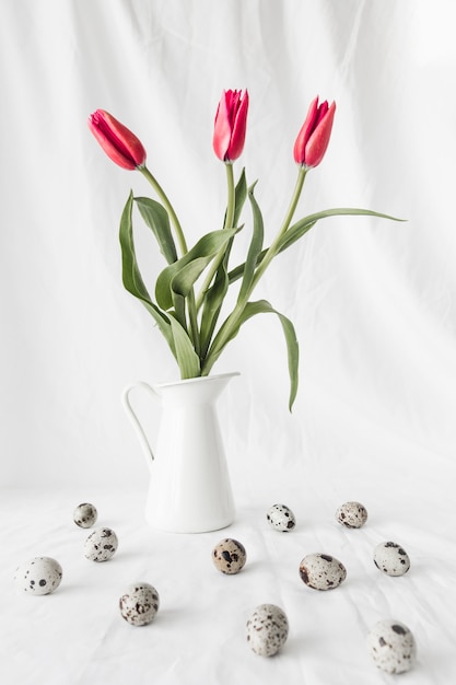 Kostenloses Foto satz von ostern-wachteleiern nahe blumen im vase
