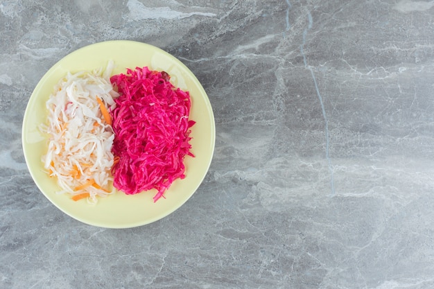 Kostenloses Foto sauerkraut auf gelbem teller. weiß und rosa.