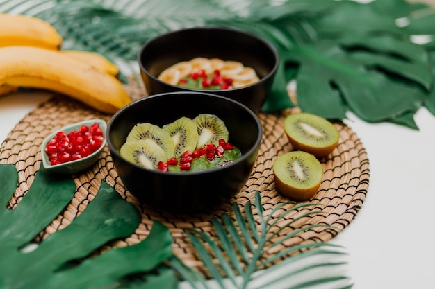 Schalen mit Kiwi, Müsli, Granat, Chia und Avocado