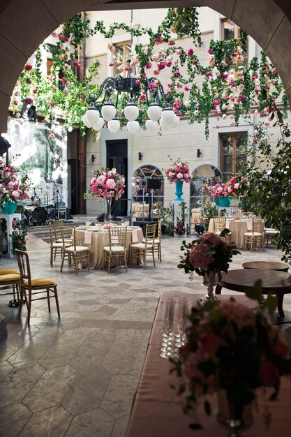 Schauen Sie aus der Ferne im Hinterhof mit Blumen zum Hochzeitsessen verziert