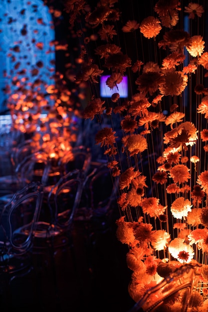 Schauen Sie hinter den Knospen der Chrysanthemen auf die Fäden an Plastikstühlen