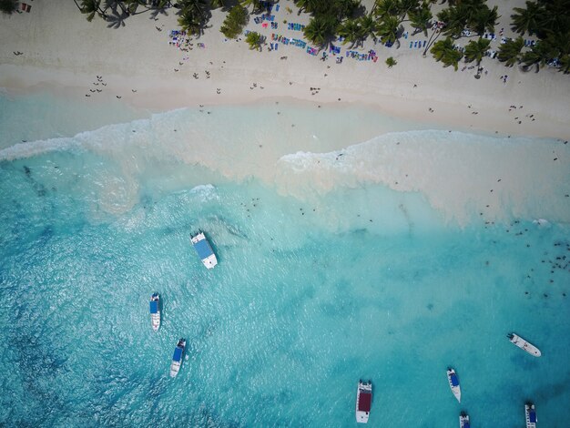 Schauen Sie von oben auf türkisfarbenem Wasser entlang des goldenen Strandes irgendwo in der Dominikanischen Republik