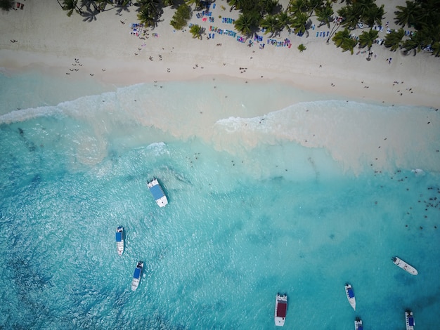 Schauen Sie von oben auf türkisfarbenem Wasser entlang des goldenen Strandes irgendwo in der Dominikanischen Republik