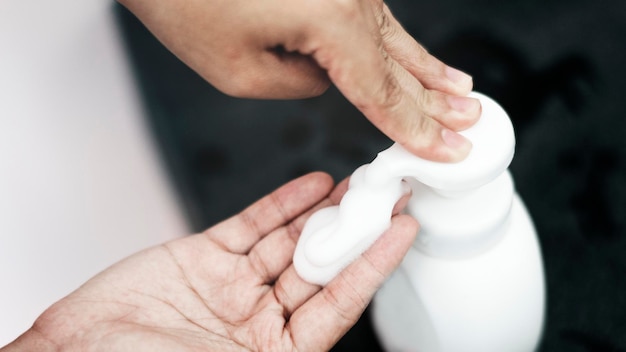 Kostenloses Foto schaumseife von hand aus einer flasche pumpen