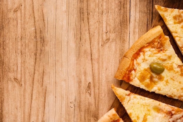 Kostenloses Foto scheibe der geschmackvollen italienischen pizza auf holztisch