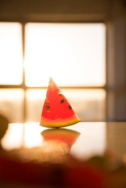 Scheibe Wassermelone auf dem Schreibtisch gegen das Unschärfenfenster