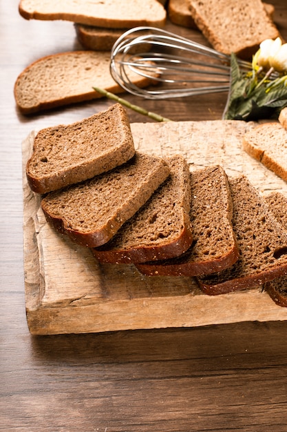 Kostenloses Foto scheiben dunkles brot auf dem küchenbrett