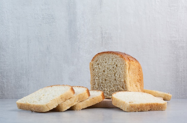 Kostenloses Foto scheiben frisches brot auf marmorhintergrund. hochwertiges foto