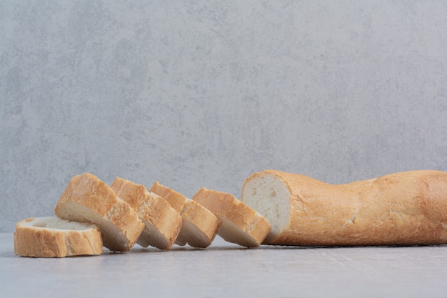 Scheiben frisches Weißbrot auf Marmorhintergrund.