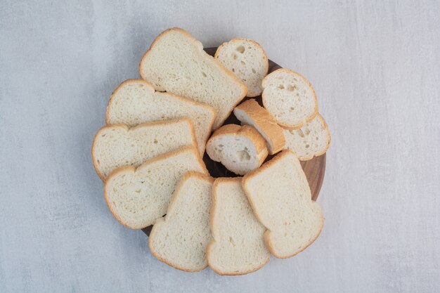 Scheiben frisches Weißbrot auf Marmorhintergrund.