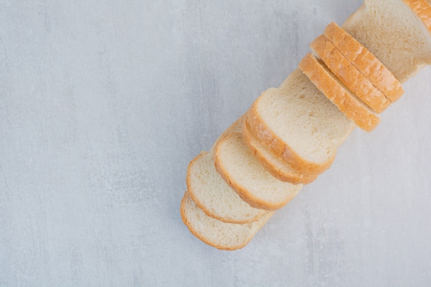 Kostenloses Foto scheiben frisches weißbrot auf marmorhintergrund.