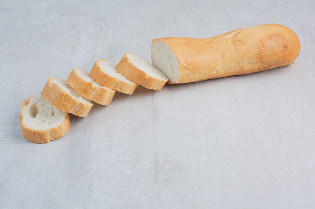 Scheiben frisches Weißbrot auf Marmorhintergrund.