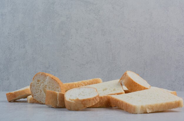 Scheiben frisches Weißbrot auf Marmorhintergrund.