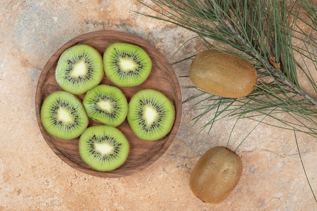 Scheiben reifer Kiwi auf Holzteller.