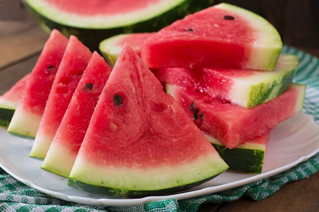 Scheiben saftiger und leckerer Wassermelone auf einem weißen Teller