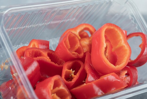 Scheiben süße rote Paprika auf Plastikteller.