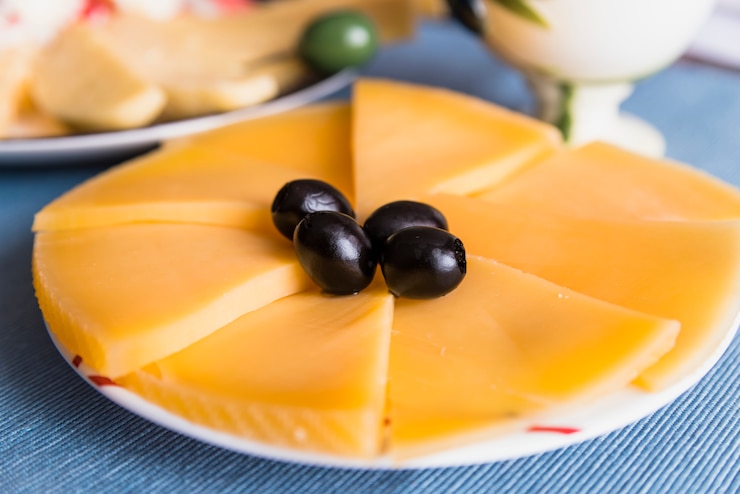 Kostenlose Foto scheiben von frischkäse mit geschmackvollen oliven auf platte