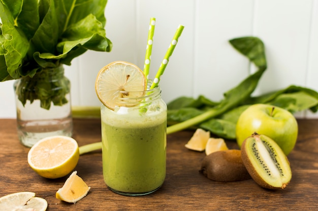 Scheiben von Früchten in der Nähe von Kräutern und Glas mit Cocktail