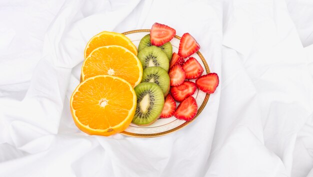 Scheiben von Orangen, Kiwi und Erdbeeren auf Platte