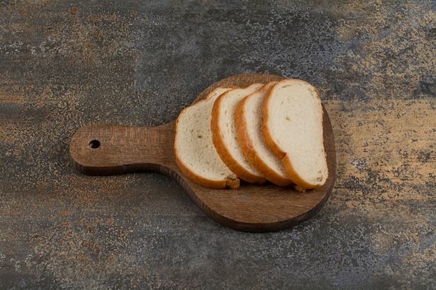 Kostenloses Foto scheiben weißbrot auf holzschneidebrett