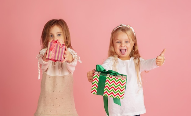 Schenken und Beschenken an den Weihnachtsfeiertagen. Gruppe glücklicher lächelnder Kinder, die Spaß haben