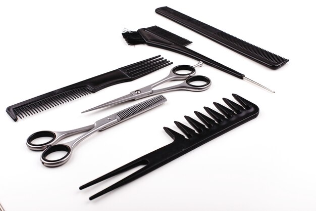 Scheren und Kämme für Haarschnitt und Behandlung liegen auf einem weißen Tisch