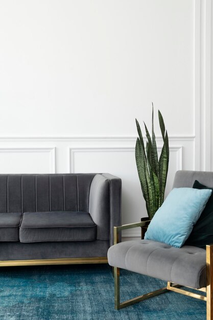 Schickes Wohnzimmer mit moderner Luxusästhetik aus der Mitte des Jahrhunderts mit grauer Samtcouch und blauem Teppich