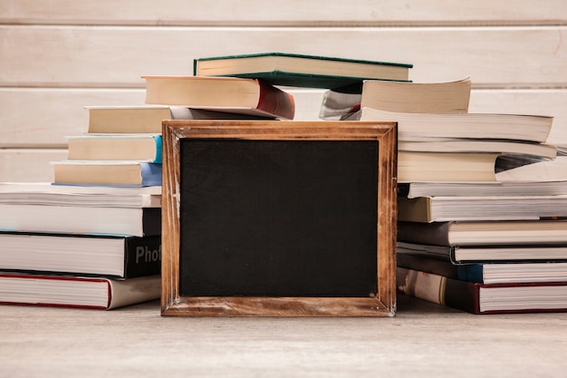 Kostenloses Foto schiefer vor stapel von büchern