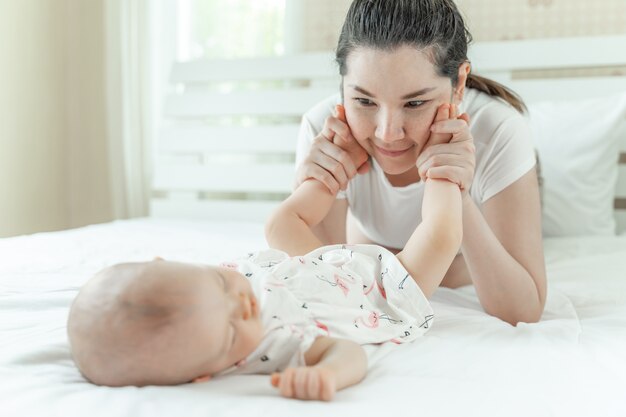 Schlafendes Baby und Mutter, die mit Babyfüßen spielt