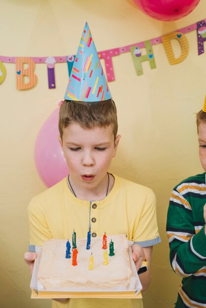 Schlagkerzen des Jungen auf Kuchen