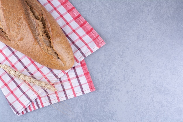 Schlagstockbrot auf einem Handtuch auf Marmoroberfläche