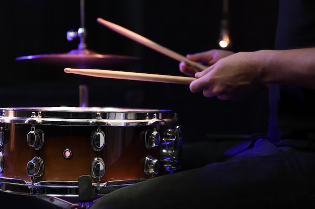 Schlagzeuger spielt Drumsticks auf einer Snaredrum im Dunkeln. Konzert- und Live-Performance-Konzept.