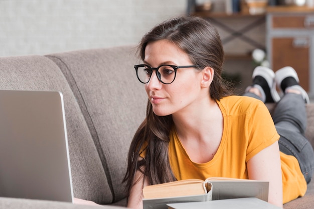 Kostenloses Foto schlauer junger student mit laptop und büchern