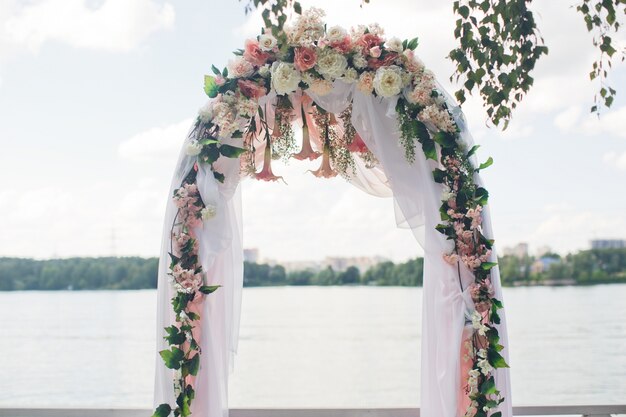 Schleier hängt vom Hochzeitsaltar mit rosa und weiß verziert