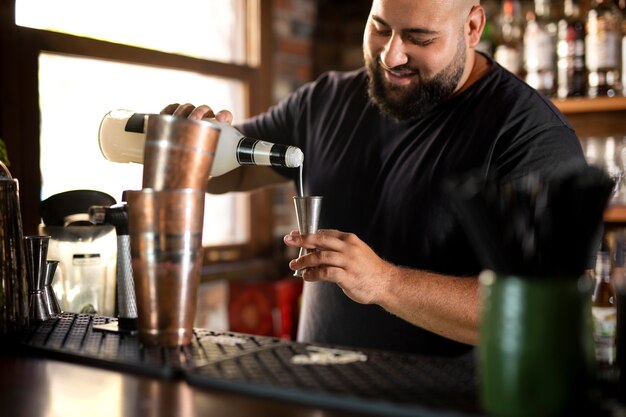 Schließen Sie den Barkeeper, der ein köstliches Getränk kreiert