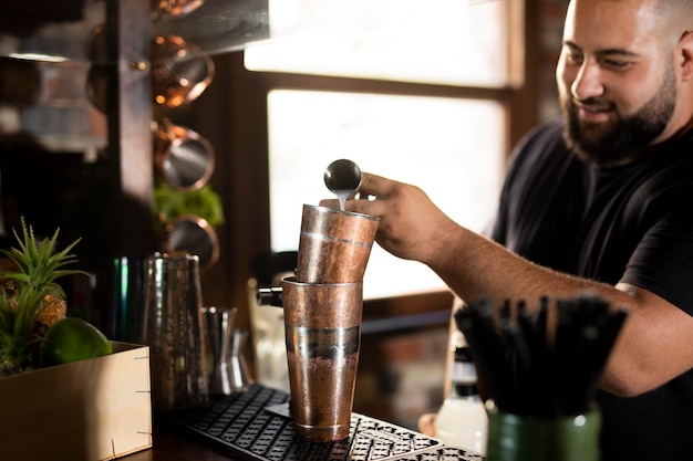 Schließen Sie den Barkeeper, der ein köstliches Getränk kreiert