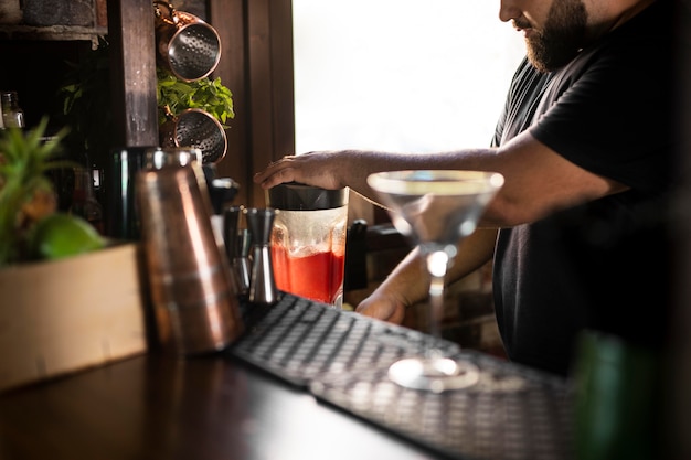 Schließen Sie den Barkeeper, der ein köstliches Getränk kreiert