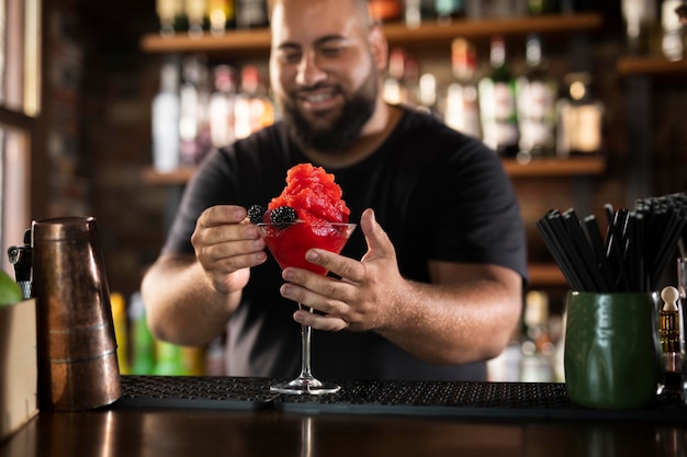 Schließen Sie den Barkeeper, der ein köstliches Getränk kreiert