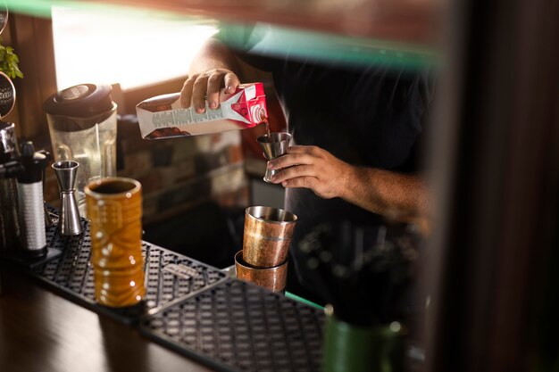 Schließen Sie den Barkeeper, der ein köstliches Getränk kreiert