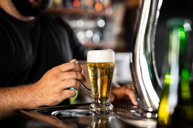 Schließen Sie den Barkeeper, der ein köstliches Getränk kreiert