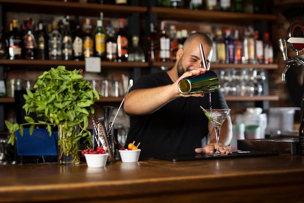 Schließen Sie den Barkeeper, der ein köstliches Getränk kreiert