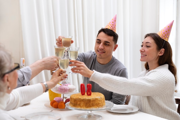 Schließen Sie die glückliche Familie, die mit den Gläsern anstößt