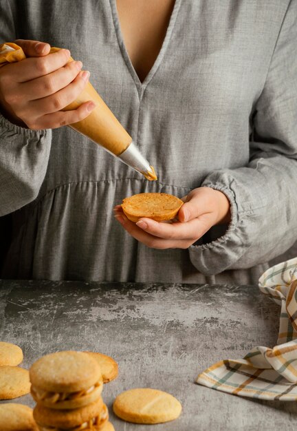 Schließen Sie die Hände, die Alfajores vorbereiten