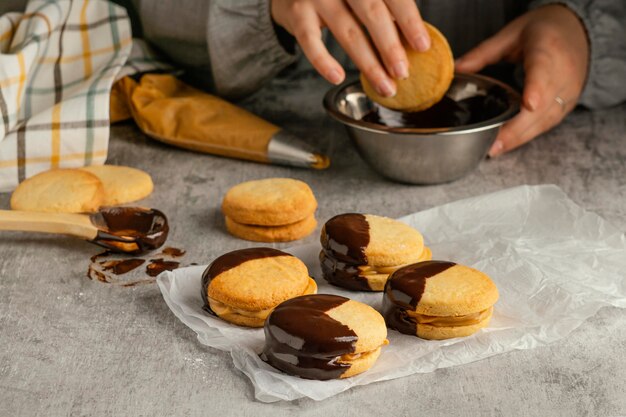 Schließen Sie die Hände, die Alfajores vorbereiten