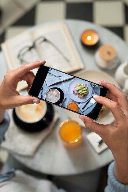 Schließen Sie die Hände, die Lebensmittelfotos mit dem Telefon machen