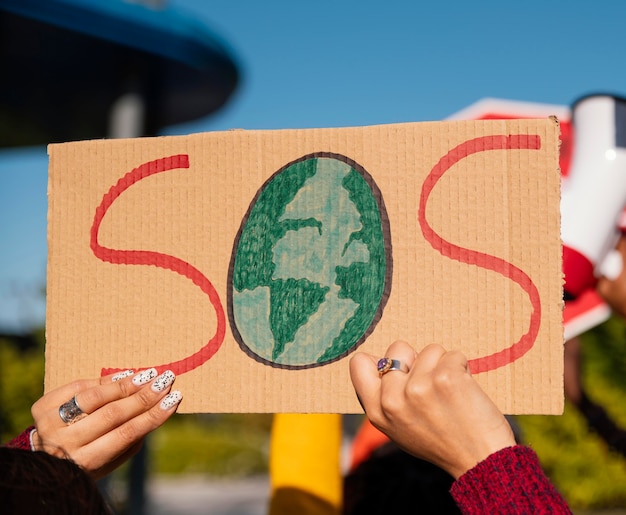 Schließen Sie die Hände, die mit Plakat protestieren