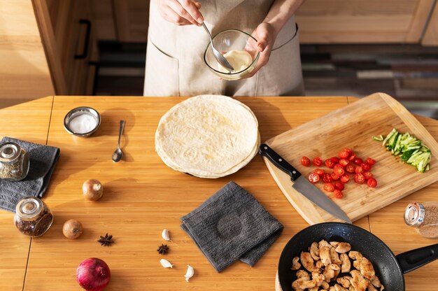 Schließen Sie die Hände, die mit Soße kochen