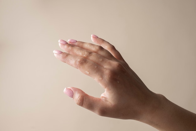 Schließen Sie die hydratisierte Hand mit Wassertropfen