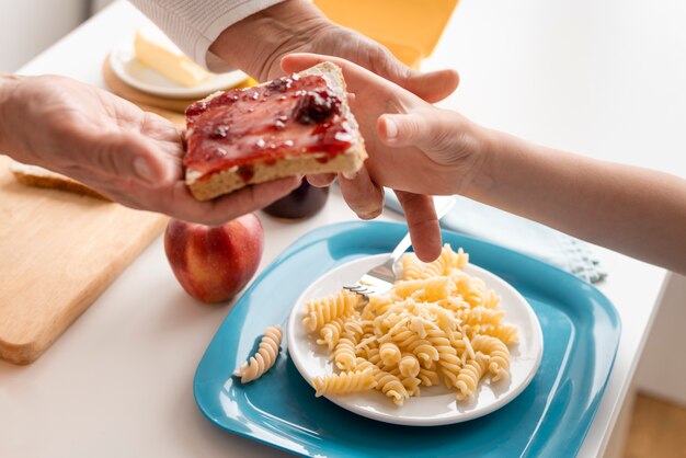 Schließen Sie Hände, die Brot mit Marmelade halten