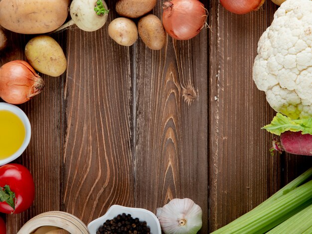 Schließen Sie herauf Ansicht des Gemüses als Kartoffelzwiebel-Knoblauch-Blumenkohl und andere mit Butter auf hölzernem Hintergrund mit Kopienraum